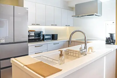 a white kitchen with a sink and a microwave at Penthouse Ueno in Tokyo