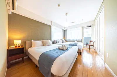 two beds in a hotel room with a large window at Penthouse Ueno in Tokyo