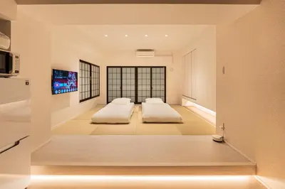 two beds in a living room with a tv at Cocono Apartment Hotel in Tokyo