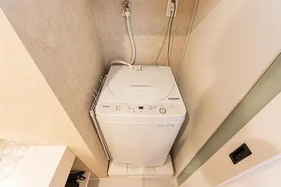 a washer and dryer in a small bathroom at Cocono Apartment Hotel in Tokyo
