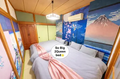 a bedroom with two beds with a sign on it at 1200IN&OUT 5people 35m2 2Queenbed! 1sofabed! Exclusive house Shinjuku 18 minutes Shibuya 22 minutesIkebukuro 11 minutes in Tokyo