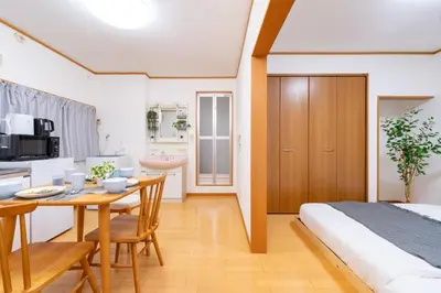 a bedroom with a table and a bed and a kitchen at 101 Tokyo Ikebukuro apartment near Pokemon Center in Tokyo