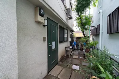 a green door on the side of a building at 101 Tokyo Ikebukuro apartment near Pokemon Center in Tokyo