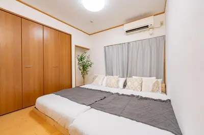 a bedroom with a large white bed and wooden cabinets at 101 Tokyo Ikebukuro apartment near Pokemon Center in Tokyo