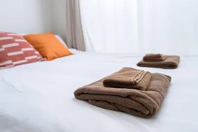 a bed with two towels sitting on top of it at Sakura Court Ebisu 101 in Tokyo