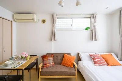 a room with a bed and a table and a couch at Sakura Court Ebisu 101 in Tokyo