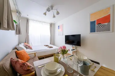 a small living room with a bed and a table at Sakura Court Ebisu 101 in Tokyo