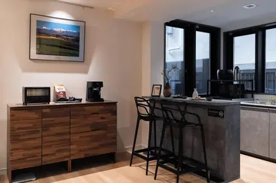 a kitchen with a bar with two stools and a counter at F&F OMOTESANDO Designer 6LDK near Harajuku&Shibuya in Tokyo