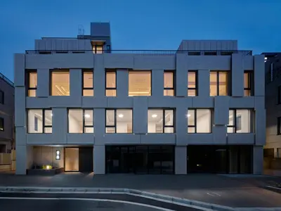 a large white building with many windows at night at F&F OMOTESANDO Designer 6LDK near Harajuku&Shibuya in Tokyo