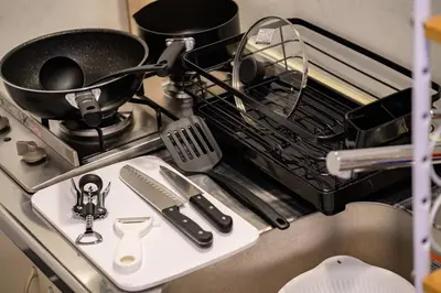 a dish drying rack with a pan and other kitchen utensils at Sakura Court Ebisu 105 in Tokyo