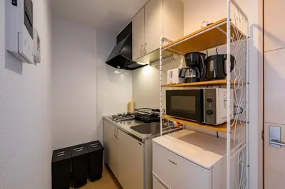 a small kitchen with a stove and a microwave at Sakura Court Ebisu 105 in Tokyo