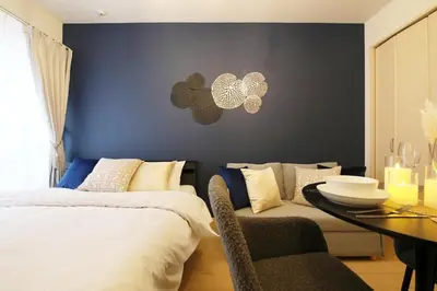 a bedroom with a blue wall with a bed and a table at Sakura Court Ebisu 203 in Tokyo