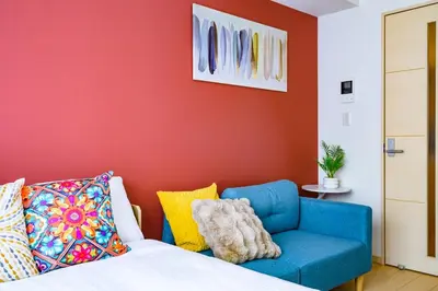 a living room with a blue couch and colorful pillows at Sakura Court Ebisu 202 in Tokyo