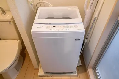 a washing machine in a bathroom next to a toilet at Sakura Court Ebisu 202 in Tokyo