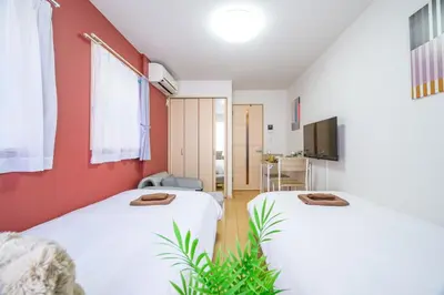 two beds in a room with red walls at Sakura Court Ebisu 205 in Tokyo