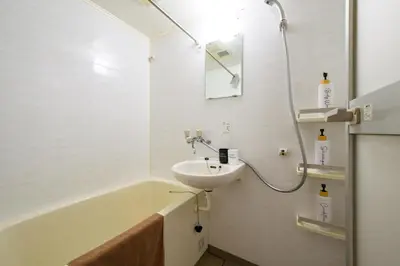 a white bathroom with a sink and a bath tub at Sakura Court Ebisu 205 in Tokyo