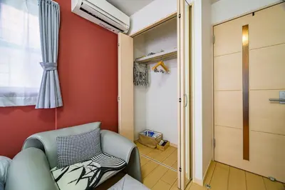 a living room with a chair and a closet at Sakura Court Ebisu 205 in Tokyo