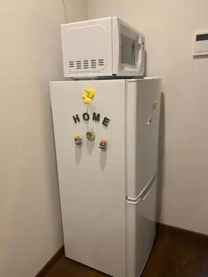 a white refrigerator with a microwave on top of it at \u4e1c\u4eac\u90fd\u5185\u5bbe\u9986Nexus villa in Tokyo