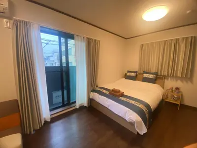 a bedroom with a bed and a large window at \u4e1c\u4eac\u90fd\u5185\u5bbe\u9986Nexus villa in Tokyo