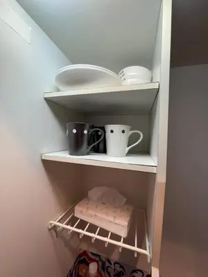a cupboard with plates and cups and dishes on it at \u6771\u4eac\u65b0\u5bbf\u306e\u5bbf in Tokyo