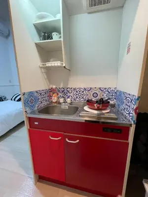 a kitchen with a red sink in a room at \u6771\u4eac\u65b0\u5bbf\u306e\u5bbf in Tokyo