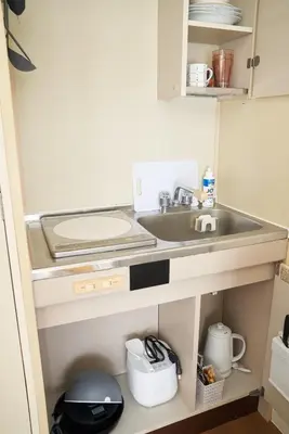 a small kitchen with a sink and a counter at Sgc\u4e16\u7530\u8c371\u4e01\u76ee in Tokyo