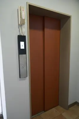 a elevator door with a sign on a wall at Sgc\u4e16\u7530\u8c371\u4e01\u76ee in Tokyo