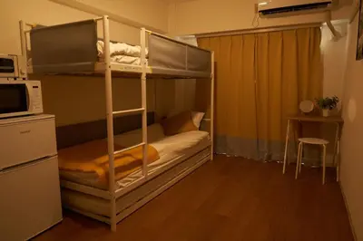 a bedroom with a bunk bed with a microwave at Sgc\u4e16\u7530\u8c371\u4e01\u76ee in Tokyo