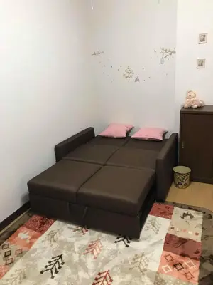 a bedroom with a brown bed with pink pillows at \u4ee5\u7433\u5c0f\u820d in Tokyo