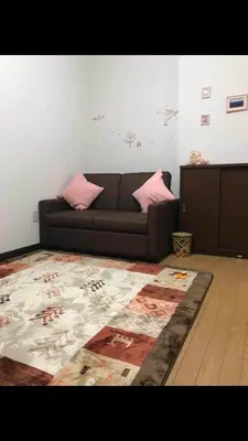 a living room with a couch and a rug at \u4ee5\u7433\u5c0f\u820d in Tokyo