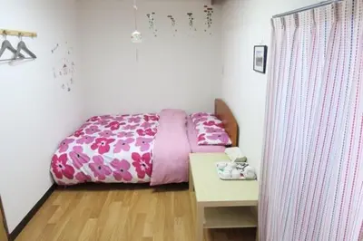 a bedroom with a pink bed and a table at \u4ee5\u7433\u5c0f\u820d in Tokyo