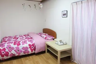 a bedroom with a pink bed and a table at \u4ee5\u7433\u5c0f\u820d in Tokyo