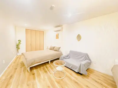a white room with a bed and a table at Season Hotel \u65b0\u5c0f\u5ca9 in Tokyo