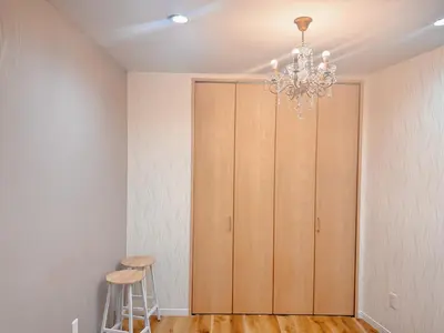 a room with a closet with two stools and a chandelier at Season Hotel \u65b0\u5c0f\u5ca9 in Tokyo