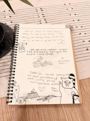 a notebook with handwriting and a drawing of a cat at Skytree Area Top-Tier Luxury, 6 min Walk to Station,Stay in a Traditional Japanese Ukiyo-e Art Villa with Rooftop, 6 min to Tokyo Skytree, Sleeps 12, 99sqm New Build, Parking, Direct Airport Access, Tokyo Experience in Tokyo