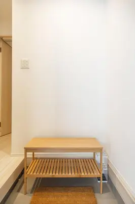 a wooden bench sitting in front of a white wall at Skytree Area Top-Tier Luxury, 6 min Walk to Station,Stay in a Traditional Japanese Ukiyo-e Art Villa with Rooftop, 6 min to Tokyo Skytree, Sleeps 12, 99sqm New Build, Parking, Direct Airport Access, Tokyo Experience in Tokyo