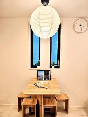 a table with benches and a clock and a chandelier at Skytree Area Top-Tier Luxury, 6 min Walk to Station,Stay in a Traditional Japanese Ukiyo-e Art Villa with Rooftop, 6 min to Tokyo Skytree, Sleeps 12, 99sqm New Build, Parking, Direct Airport Access, Tokyo Experience in Tokyo