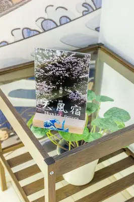 a book sitting on top of a wooden table at Skytree Area Top-Tier Luxury, 6 min Walk to Station,Stay in a Traditional Japanese Ukiyo-e Art Villa with Rooftop, 6 min to Tokyo Skytree, Sleeps 12, 99sqm New Build, Parking, Direct Airport Access, Tokyo Experience in Tokyo