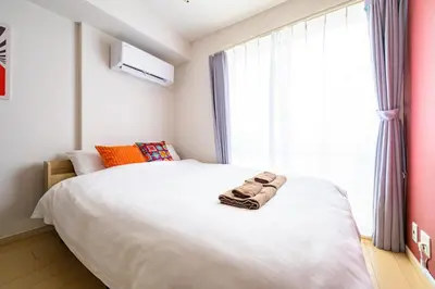a bedroom with a large bed with towels on it at Sakura Court Ebisu 303 in Tokyo