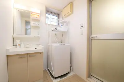 a small bathroom with a sink and a refrigerator at Sakura Court Ebisu 305 in Tokyo