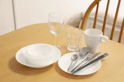 a wooden table with plates and wine glasses and silverware at Sakura Court Ebisu 305 in Tokyo
