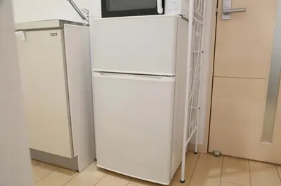 a white refrigerator with a microwave on top of it at Sakura Court Ebisu 305 in Tokyo
