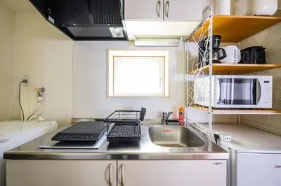 a small kitchen with a sink and a microwave at Sakura Court Ebisu 401 in Tokyo