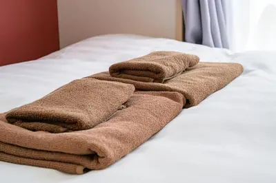 two brown towels sitting on top of a bed at Sakura Court Ebisu 401 in Tokyo