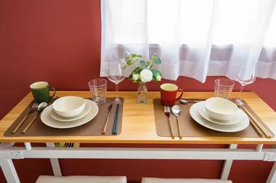 a wooden table with plates and utensils on it at Sakura Court Ebisu 401 in Tokyo