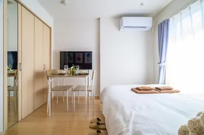a bedroom with a bed and a table with chairs at Sakura Court Ebisu 402 in Tokyo