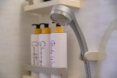 a shower head and three bottles on a shelf at Sakura Court Ebisu 402 in Tokyo