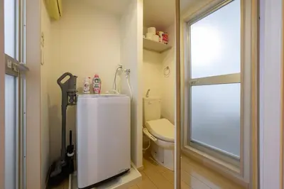 a small bathroom with a toilet and a window at Sakura Court Ebisu 403 in Tokyo