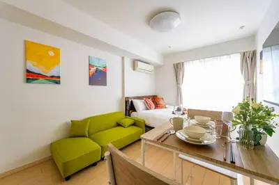 a living room with a green couch and a table at Sakura Court Ebisu 403 in Tokyo