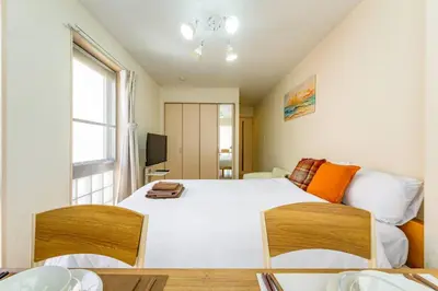 a bedroom with a large white bed and a window at Sakura Court Ebisu 405 in Tokyo